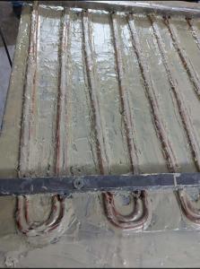 Defreezer panel with serpentine copper coil bonded using thermal paste instead of solder