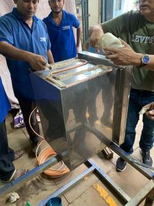 Workshop team applying thermal paste on a defreezer cabinet